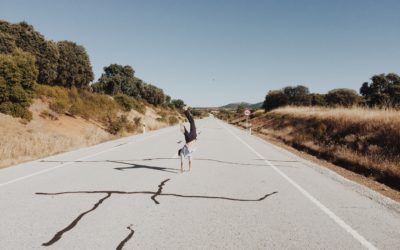 Image of man cartwheeling down an empty single lane highway