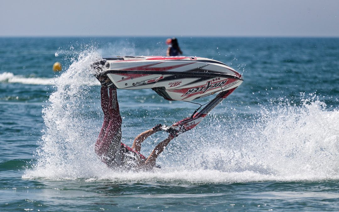 Photo of a person riding a seadoo with their head in the water and the seadoo above them