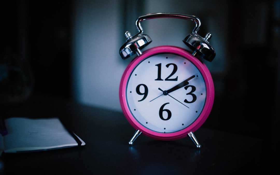 Photo of a hot pink old school alarm clock