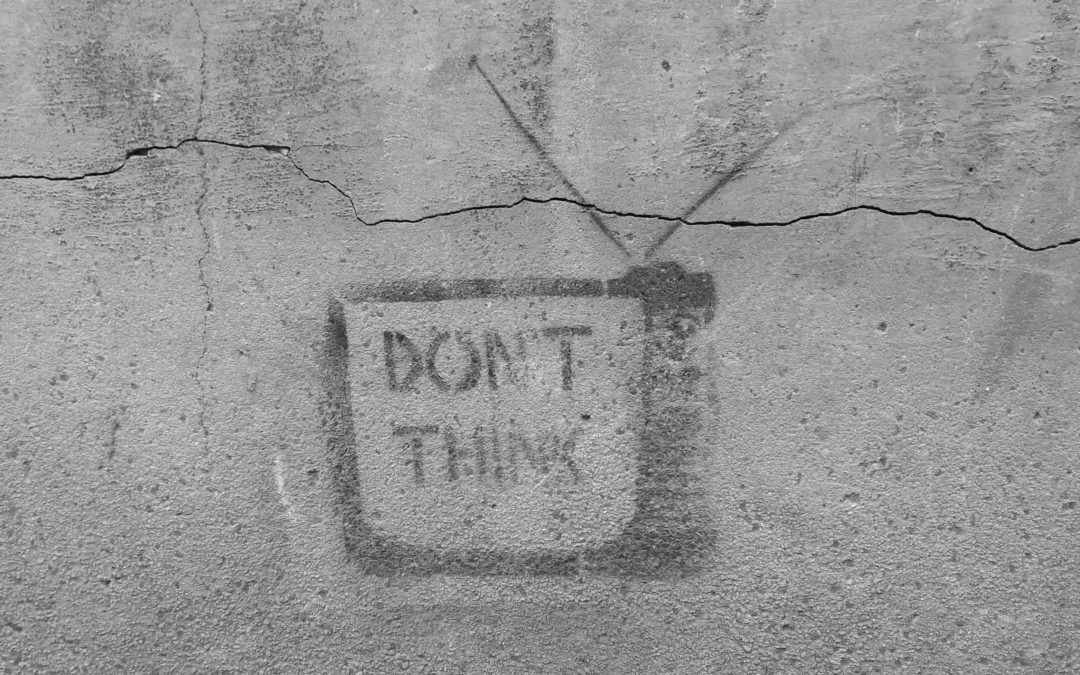 An image of a painting on a cement wall that says "Don't think" inside of a television