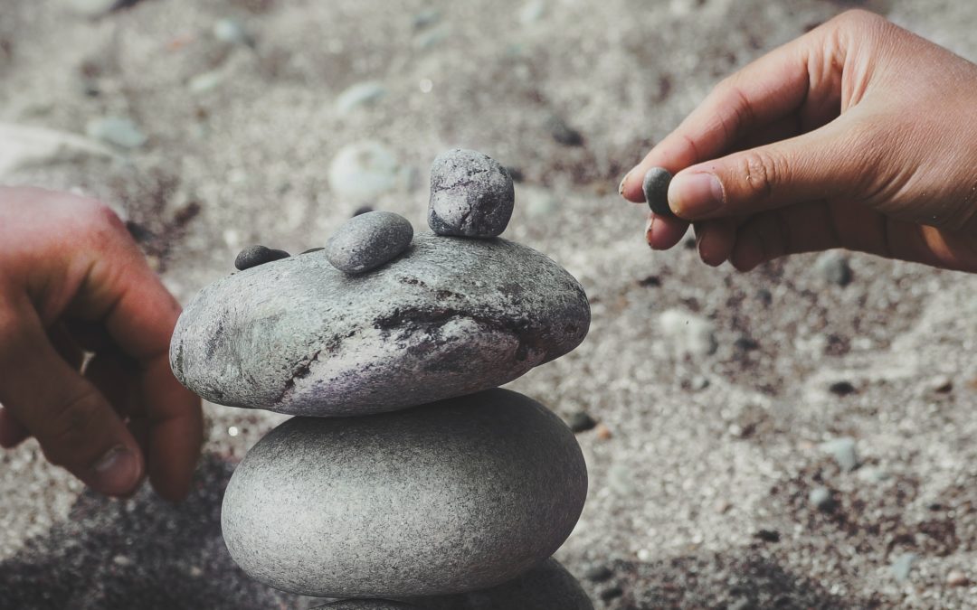 People building a structure out of rocks and pebbles