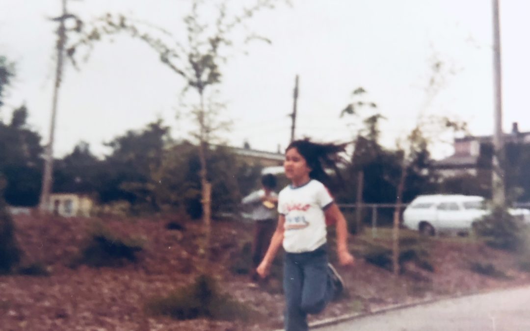 A girl running down a gravel path on a grey day crying because she is finishing last in a race