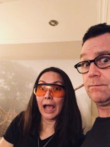 Photo of Kirsten wearing blue blockers and her husband looking surprised