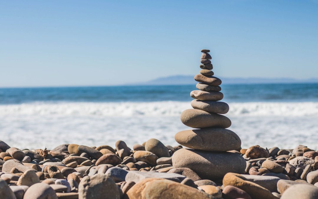 A stack of rocks on a a rocky beach with the ocean in the background