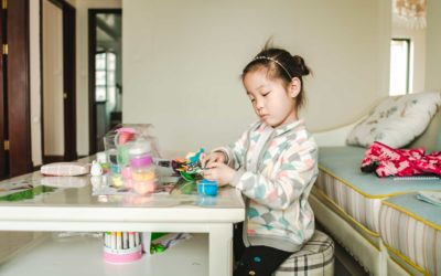 Little girls playing with crafts on a white table