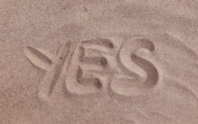 The word "Yes" drawn in the sand