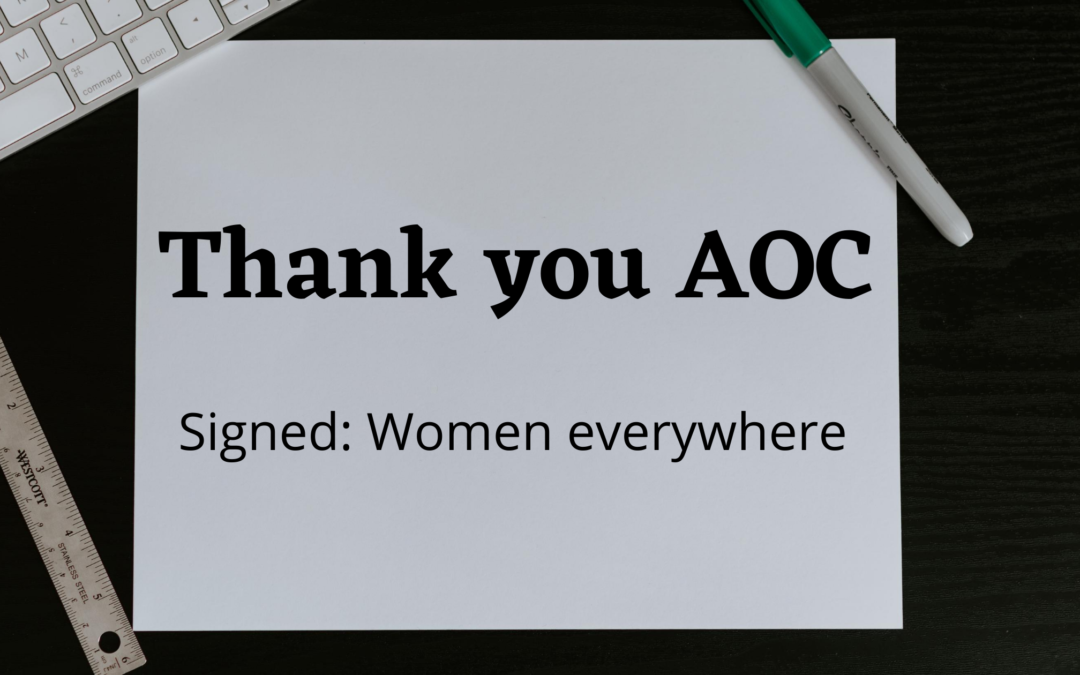 Photo of a paper on a desk with a keyboard, ruler and marker beside it that says: "Thank you AOC, Signed: Women Everywhere"