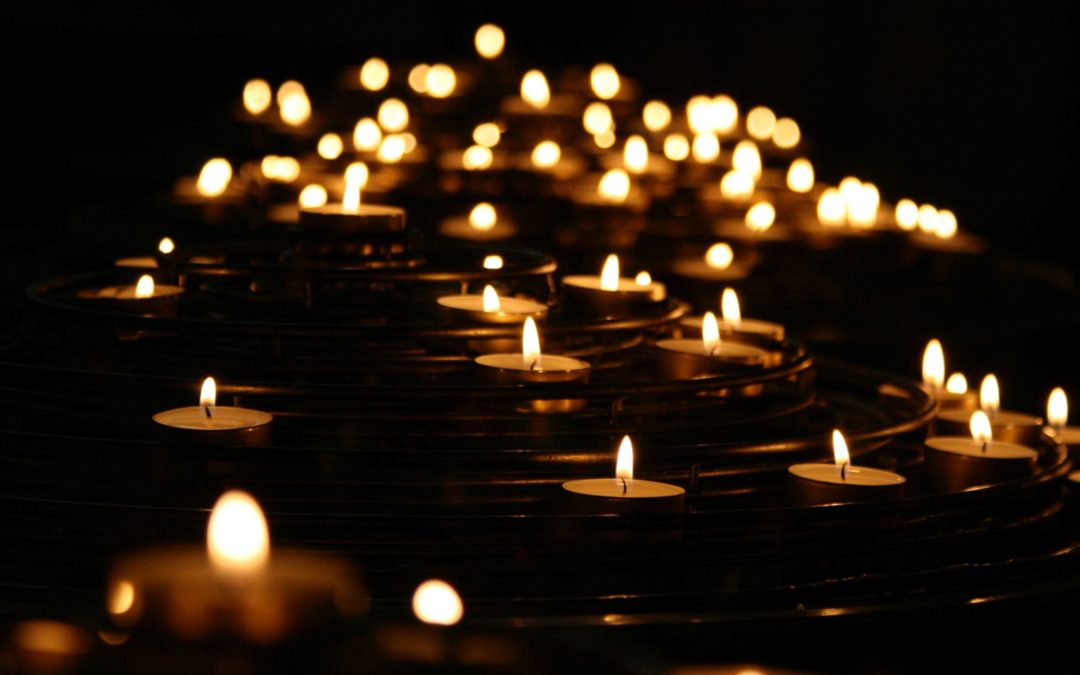 Lit candles glowing in the darkness