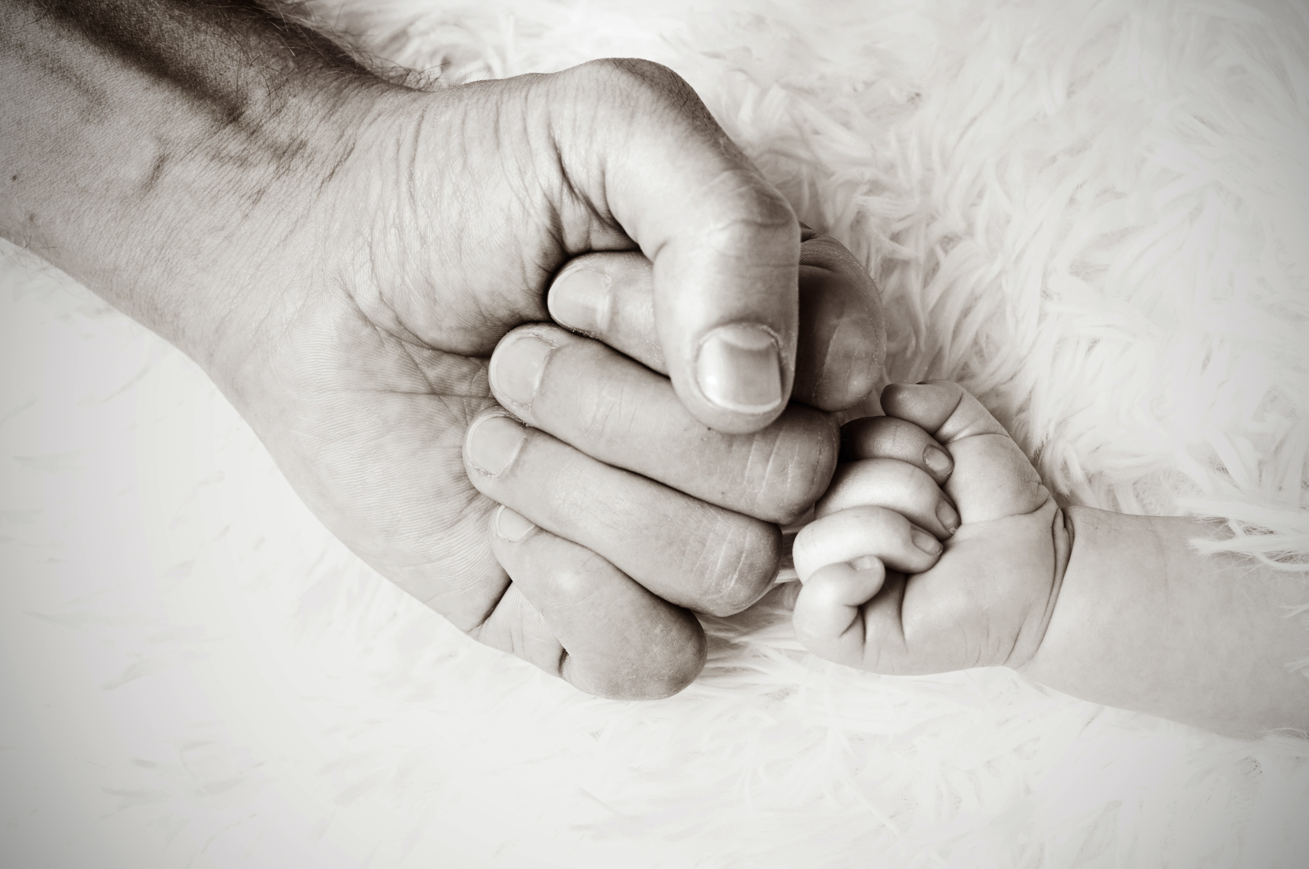 Fathers hand fist bumping baby's hand